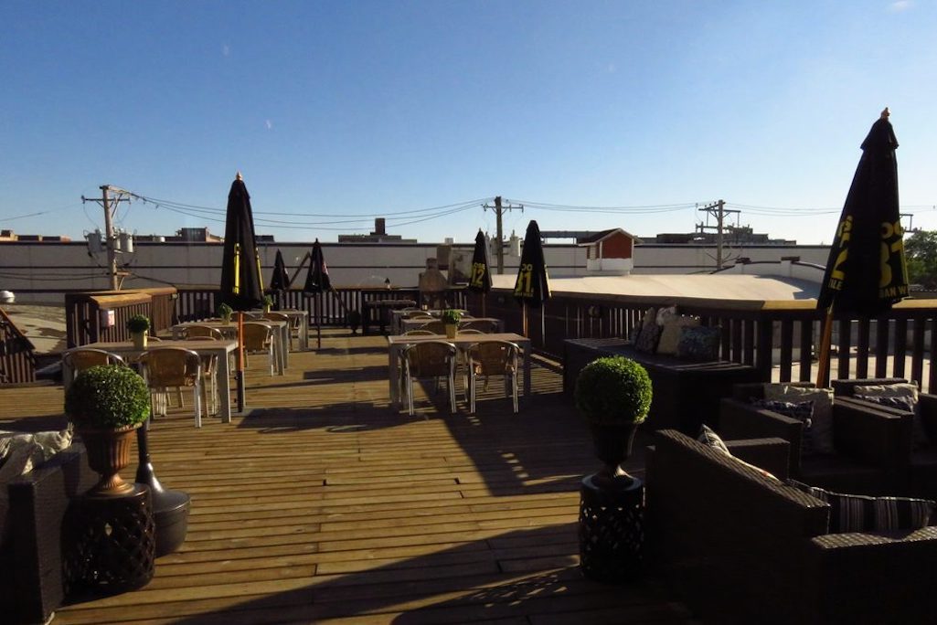 The Bottom Lounge rooftop deck with tables and umbrellas